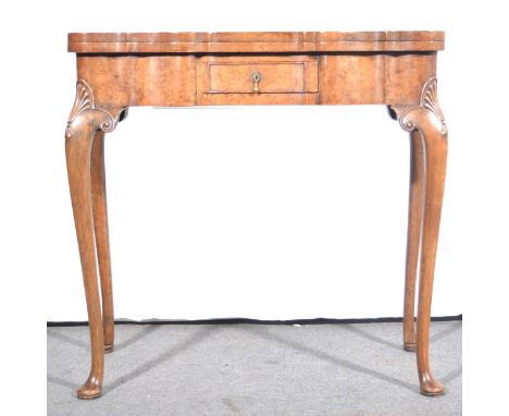 A Queen Anne style burr walnut fold-over card table, 20th Century, serpentine cross-banded top, baize lined, central drawer, 