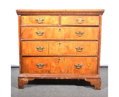 A walnut chest of drawers, 18th Century and later, rectangular top with broad cross-banding, above a moulded frieze, two shor