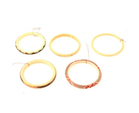 Five vintage celluloid ivorine bangles, a 10mm bangle set with seventy-one clear paste, internal diameter 70mm, three stained