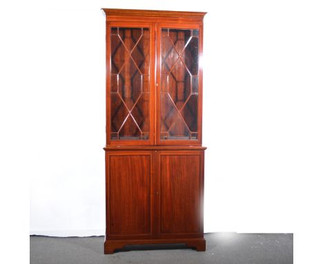 An Edwardian mahogany bookcase, with boxwood stringing, two astragal glazed panelled doors to the upper section, two panelled