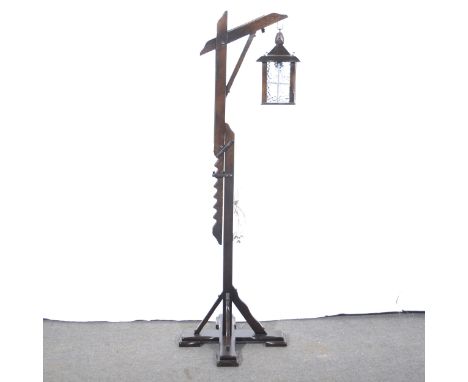 An adjustable standard lamp, stained oak, in the form of a street lantern, height 152cm; a stained wood wall clock, 1930s, ei