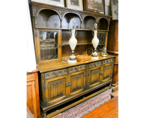 An Old Charm reproduction oak dresser with shelf and leaded glazed back, drawers and cupboards under with linen fold panels 7