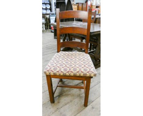 A set of four mahogany ladder back style dining room chairs with panel seats and loose squab cushions