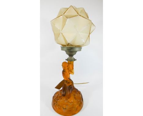 An Art Deco amber pressed glass table lamp base modelled as a seated nude figure with associated star burst style lamp shade.