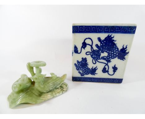 A Chinese blue and white flower brick together with a carved jade model of birds