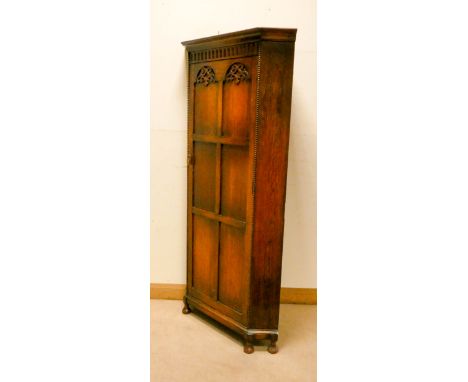 A 1930's oak corner wardrobe with fielded panel door 