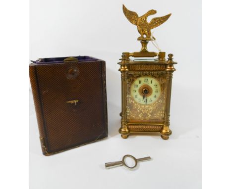 A decorative brass cased carriage clock, cream enamel chapter ring signed Bachmann Guernsey with leather carry case, clock 14