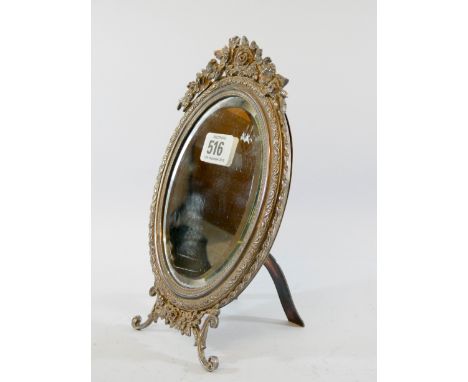 A good quality silver plated oval mirror on easel stand, highly decorated and engraved frame surmounted by swags of roses 