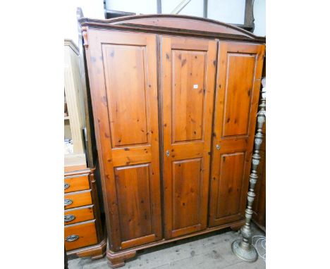 A red pine three door partly fitted wardrobe 4'6 wide 