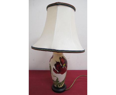 Moorcroft table lamp, ovoid body decorated with a red poppy with green leafage on a cream ground, wooden base and with shade 