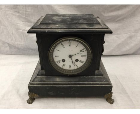 A HEAVY VINTAGE MANTEL CLOCK WITH BRASS DECORATION AND CLAW FEET 
