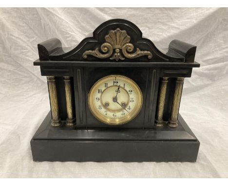 A SLATE VICTORIAN MANTLE CLOCK WITH ENAMELLED FACE, COLUMN DECORATION AND PENDULUM.  WIDTH 38CM, HEIGHT 31CM 