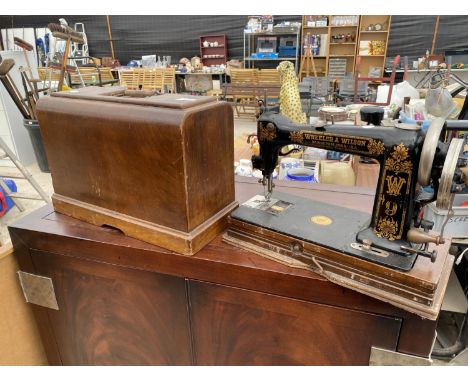 A VINTAGE WHEELER AND WILSON SEWING MACHINE WITH WOODEN CARRY CASE 