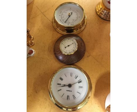 A BRASS ROUND BAROMETER, ROUND BRASS CLOCK AND A SMALLER ROUND WOODEN BAROMETER 