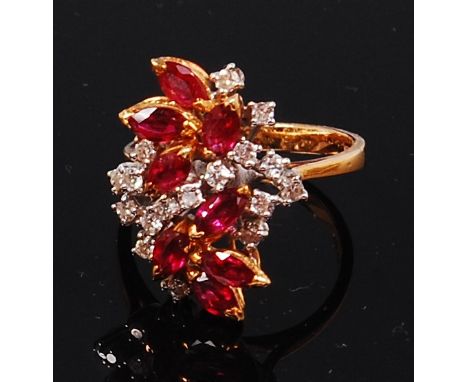 A ladies 18ct gold, ruby and white sapphire set cocktail ring, arranged as eight marquise cut rubies, dispersed with small cl