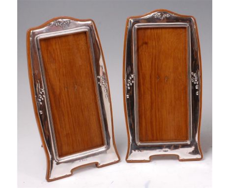 A matched pair of Art Nouveau silver photograph frames, each of shaped elongated portrait form, the silver embossed with corn