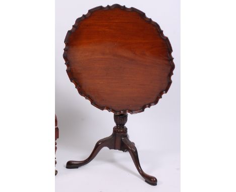 A circa 1900 walnut pedestal tripod table, in the mid-18th century style, having a piecrust top on a gun barrel turned urn co