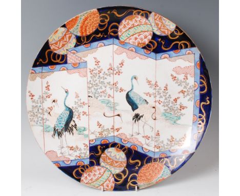 A late 19th century Japanese Imari porcelain charger, decorated with a sectional screen depicting storks amidst a landscape, 