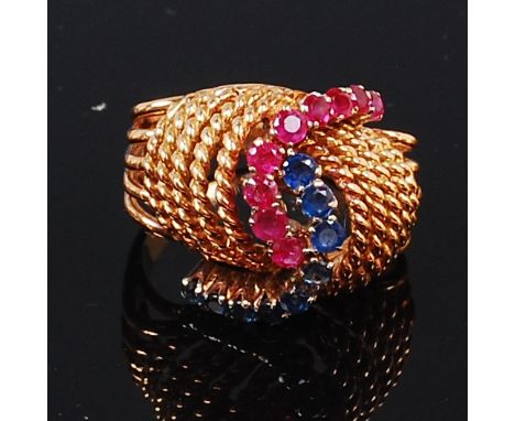 An 18ct gold, ruby and sapphire set dress ring, arranged as two rows of claw set and graduating round cut rubies and sapphire