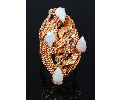 A contemporary yellow metal, opal and diamond set ladies cocktail ring, the four cabochon opals dispersed with five small cla