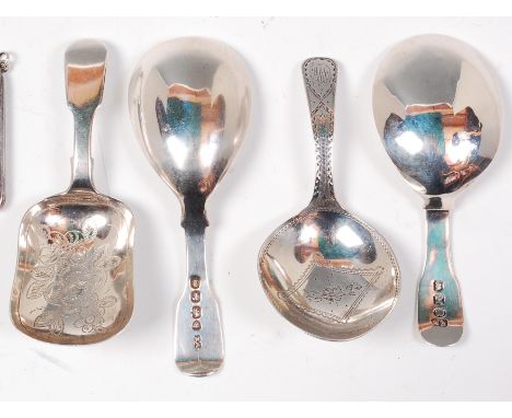 An early 19th century silver caddy spoon, having bright cut engraved decoration, London 1818; and three others, all with Lond