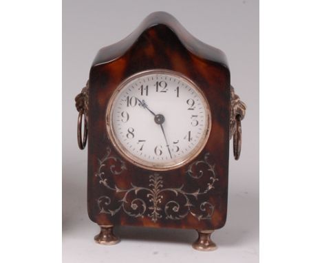 An Edwardian tortoiseshell and silver small mantel clock, the shaped case with Arabesque silver inlay, lion mask ring carry h