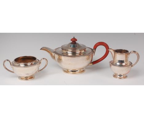 A silver three piece teaset, comprising teapot, twin handled sugar and cream, each of squat circular tapering form, the teapo