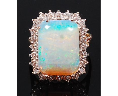 A ladies 18ct gold and diamond dress ring, arranged as a large claw set cabochon opal measuring approx 6 x 13 x 4mm, in a sur