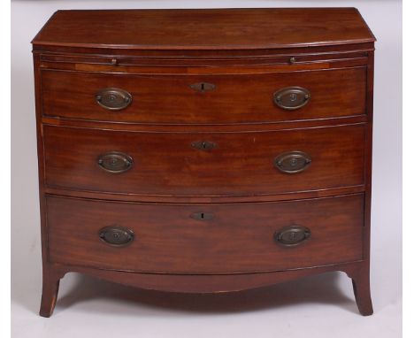 A Regency period mahogany bowfront chest, having a brushing slide over three long graduated drawers, on splayed bracket feet 