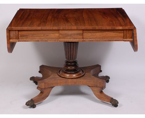 A Regency rosewood pedestal sofa table, the top having fall flaps with rounded corners above blind frieze drawers opposing du