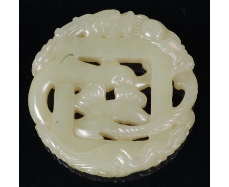 A Chinese carved green jade amulet, carved with twin dragons, dia. 5.7cm