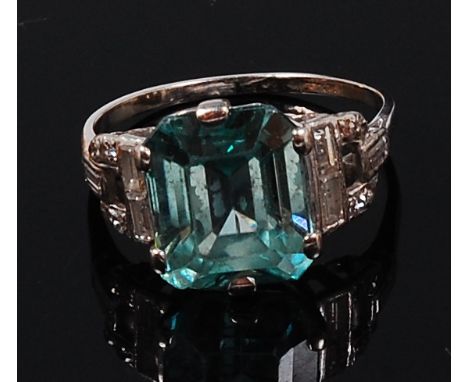 A white metal, blue topaz and diamond set dress ring, the octagonal cut topaz weighing approx 4.5ct, being claw set and flank