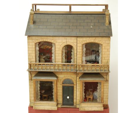 A late 19th century English double fronted dolls house and contents, the painted honey coloured stone effect wooden house wit