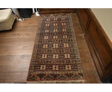 A Turkoman runner on a salmon ground with repeated geometric motifs. H.263 W.122cm 