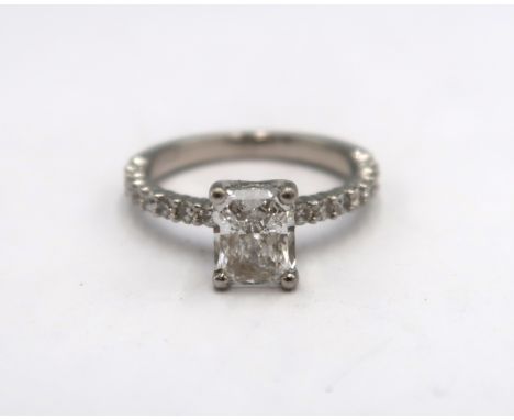 A 1ct radiant cut diamond engagement ring the central stone flanked by 16 small round cut diamonds - 3.3 grams, ring size H