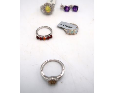 An assortment of silver jewellery. To include jelly opal and zircon cluster ring, size M. An opal three stone ring, size K. A