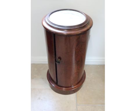 A Victorian mahogany marble top bedside cabinet of cylinder form single door with bun handle, single shelf to interior, raise