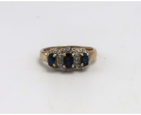 A 9ct gold dress ring set with three oval cut sapphires, each surrounded by a halo of diamond brilliants, size R, band marked