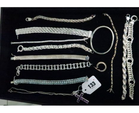 A group of silver jewellery, including a synthetic sapphire tennis bracelet, a white stone set tennis bracelet, a purple gem 