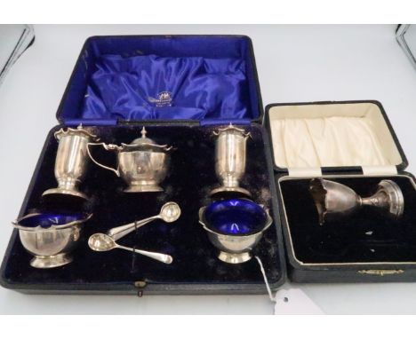 An Art Nouveau silver condiment set, of two salts, pepperettes and a mustard pot with blue glass liners to the salt and musta