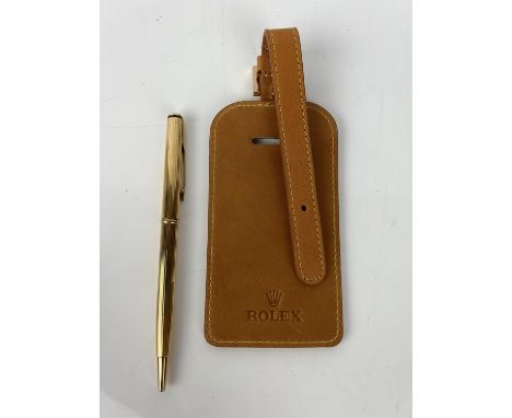 A vintage 1960 ROLEX gold coloured Parker insignia biro pen in blue inkand an unused tan kid leather ROLEX luggage tag with g