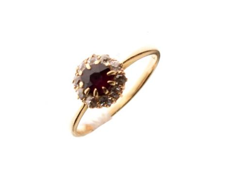 Dress ring set central ruby coloured stone with a diamond surround, the shank stamped 18ct, size M   Condition: 