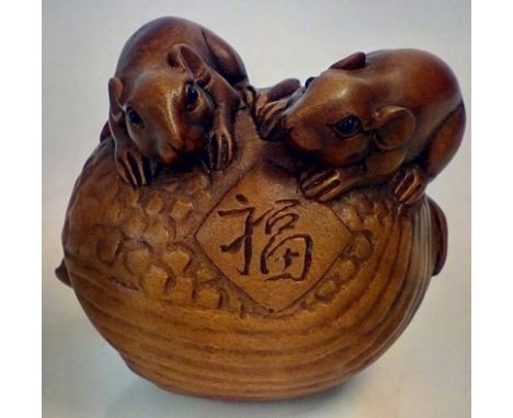 Japanese wooden netsuke with three mice amongst a nutshell, signed 
