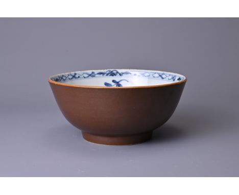 A CHINESE BATAVIA PORCELAIN BOWL, 18TH CENTURY. The interior decorated in blue and white with floral sprays, the exterior mon