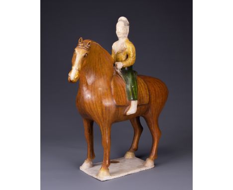 A CHINESE SANCAI GLAZED POTTERY MODEL OF A HORSE AND RIDER, TL TESTED, TANG DYNASTY (AD 618-907). Modelled standing foursquar