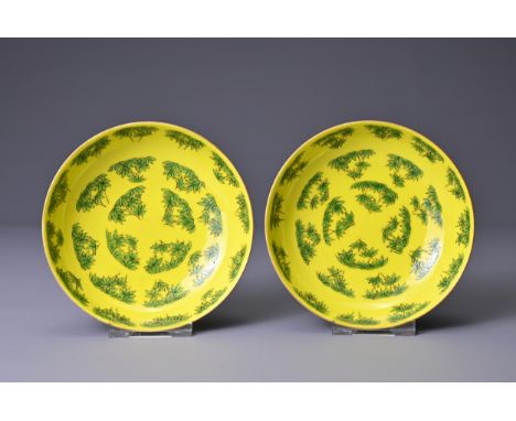 A PAIR OF CHINESE YELLOW GROUND PORCELAIN SAUCERS, TONGZHI MARKS. Each bright yellow ground with green enamel leaves pattern.