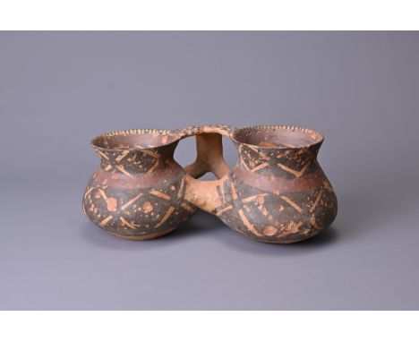 A RARE CHINESE NEOLITHIC PAINTED POTTERY 'DOUBLE CUP', MACHANG CULTURE (2500–2000 BC). The two cups are conjoined by a hollow