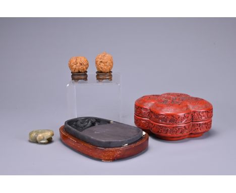 TWO CHINESE CARVED WALNUTS, A CINNABAR LACQUER BOX AND COVER, AN INKSTONE AND WOODEN CASE AND A CARVED JADE MODEL OF A FROG. 