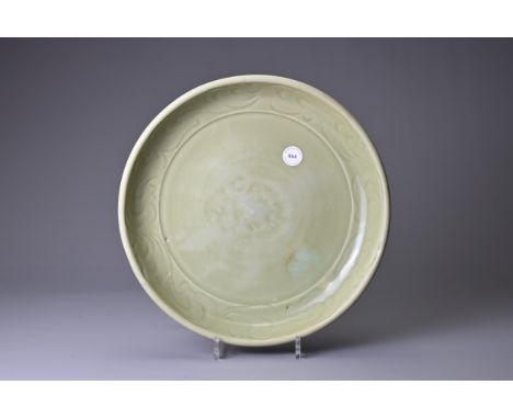 A CHINESE LONGQUAN CELADON DISH, YUAN / MING DYNASTY. Heavily potted with rounded sides decorated to the interior with a band