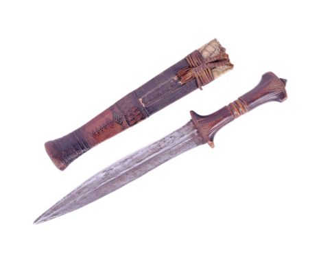 A West African Hausa People tribal dagger. Carved wooden grip with a dome shaped metal finial and the blade with a profound c